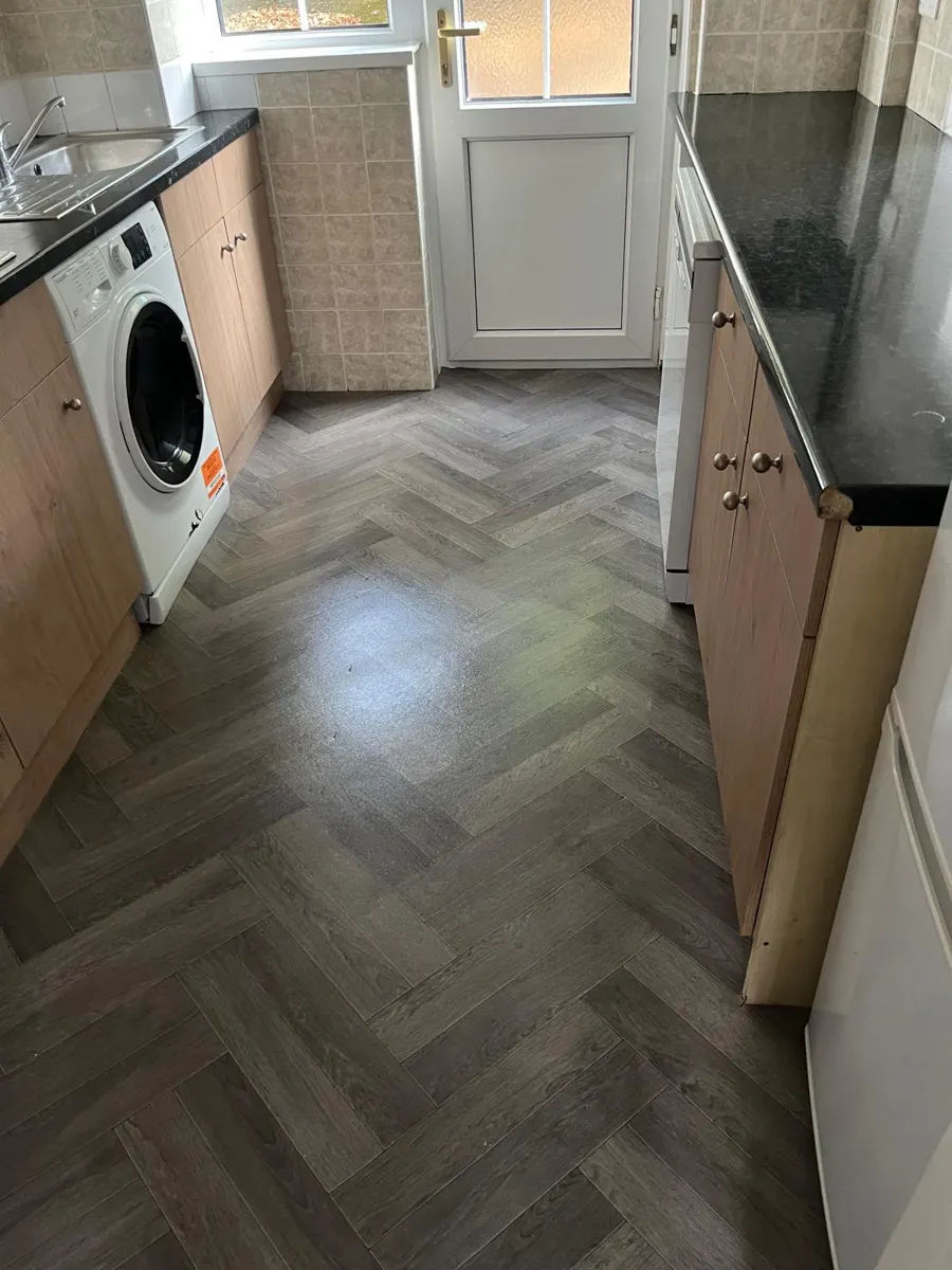 Clean galley kitchen with herringbone vinyl floor